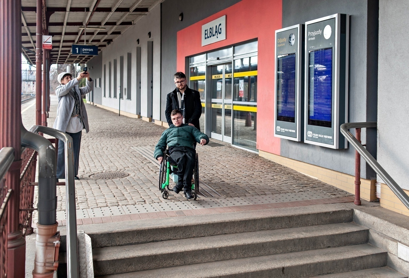 Elbląg, Mateusz Majkut (na wózku) i Artur Pytliński z NE prezentują problemy z dotarciem na elbląski dworzec PkP