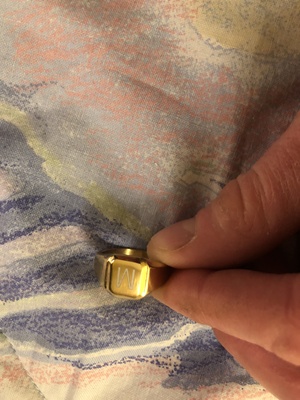 Elbląg Sprzedamsygnet zezdjęcia. Sygnet jest metalowy w kolorze złotym z literą M w głównym umiejscowieniu. Sygnet